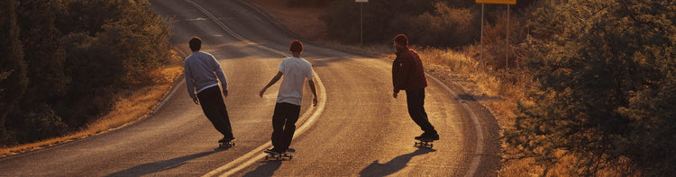 Skateboarders riding down a hill.