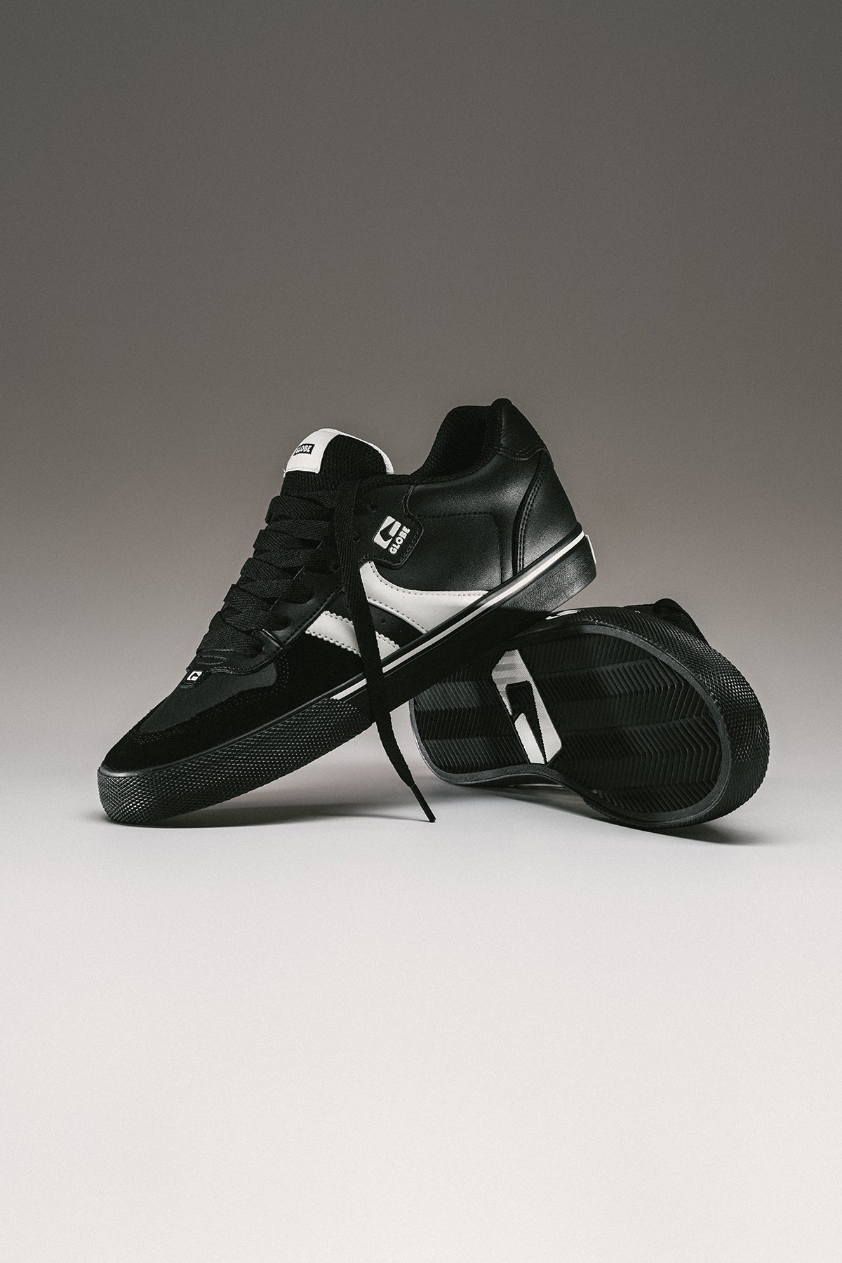 Side profile of Encore-2 Black/Antique skate shoe with white twin stripes and gum sole