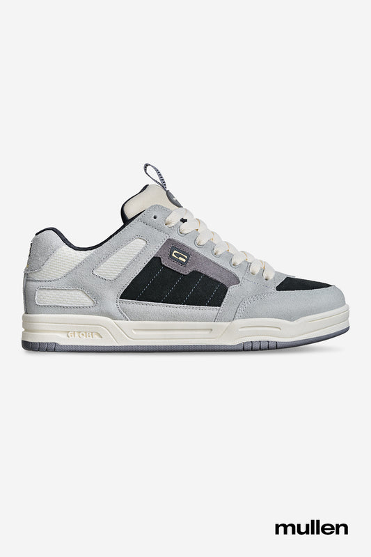 The Tilt Prime - Grey / Mullen skate shoe features light gray and black colors, white laces and accents, a thick sole, suede and mesh details. "Mullen" appears in black text to honor skate legend Rodney Mullen.