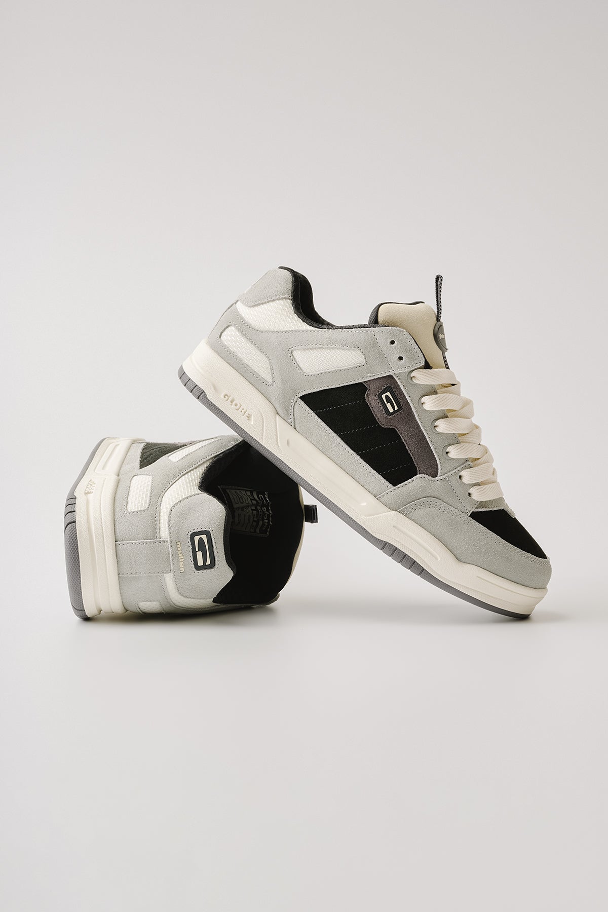 A pair of Globe Tilt Prime - Grey / Mullen low-top sneakers, one flat and one propped to display the sole and side details, shown against a plain white background.