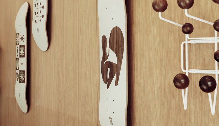 eames limited edition globe skateboard decks hanging on a wall