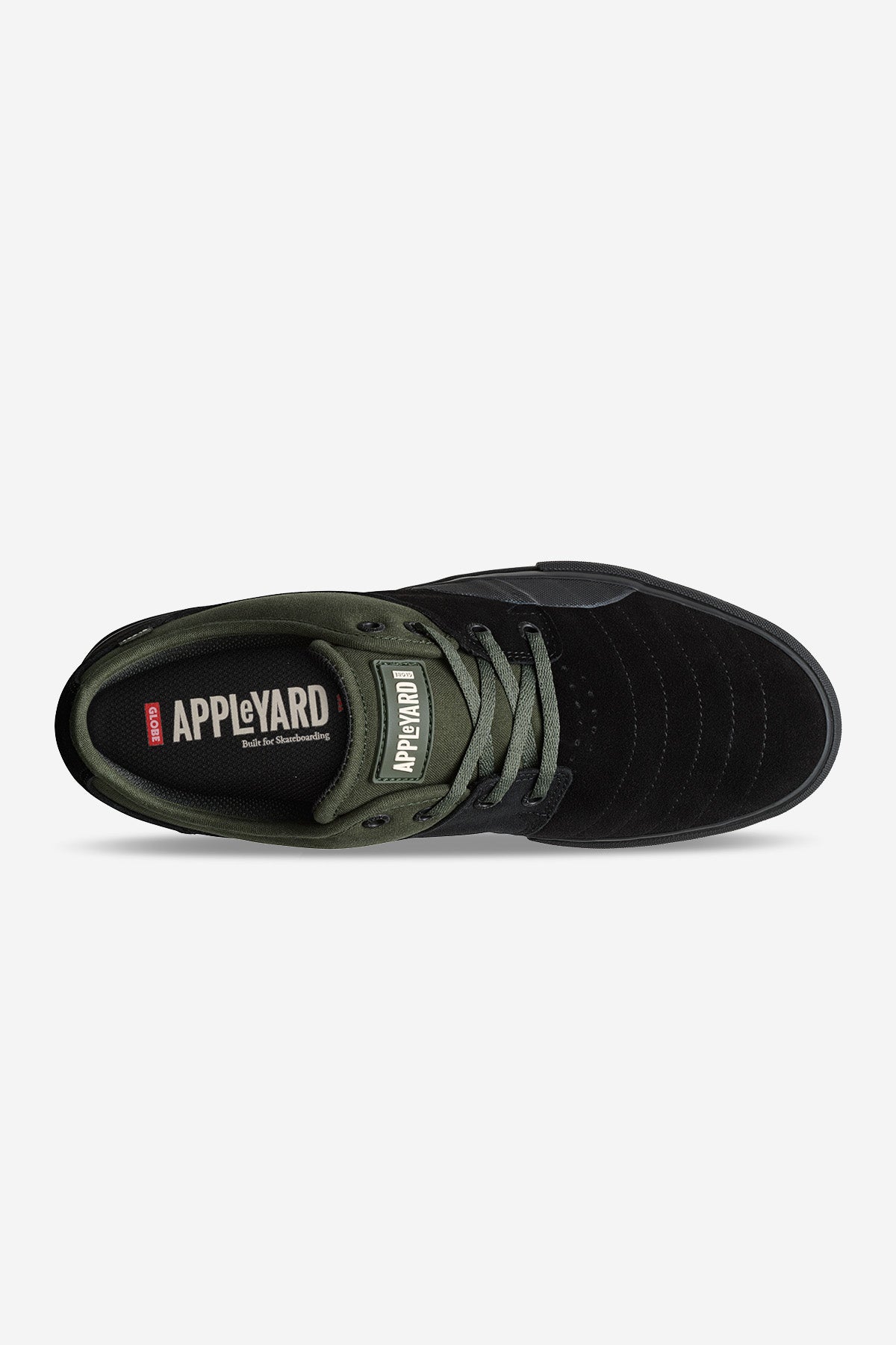 The Mahalo Plus - Black/Pine is a low-top vulcanized skate shoe in black and olive green, shown from above, featuring gray laces, Appleyard branding on the tongue and insole, and a durable rubber ollie patch for protection.