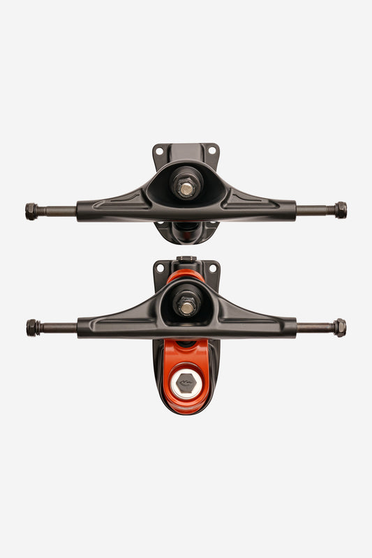 Two Slant Surf Skate Trucks 6.25" in Black/Red—one top view and one bottom view displaying axles, baseplates, and an orange bushing—are pictured on a plain white background.