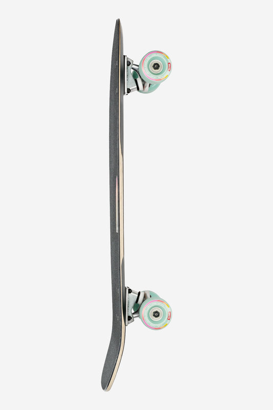 The Blazer Fuego Cruiserboard 29" - Flare is shown from the side on a white background, with black grip tape, curved nose and tail, Tensor ATG trucks, and multicolored wheels.