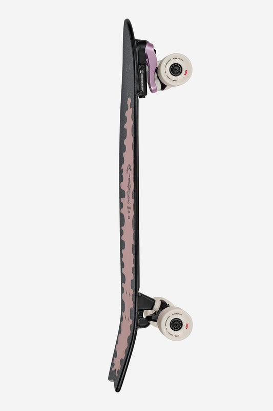 The Sun City 2 Surf Skate Board 30" - Lazy Daisy features a black deck with light pink grip tape, swallow-tail cruise shape, white wheels, black Slant surf/skate trucks, and is shown from the side against a white background.