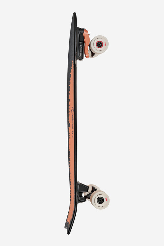 A side view of the Chromantic Surf Skate Boards 33" - Lightning Log shows its black deck, brown underside, surf/skate trucks, and white wheels with red accents, photographed against a plain white background.