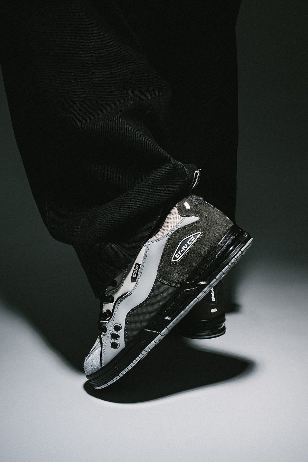CT-4 grey and black skate shoe on a bent leg, side profile.