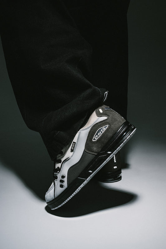 CT-4 grey and black skate shoe on a bent leg, side profile.