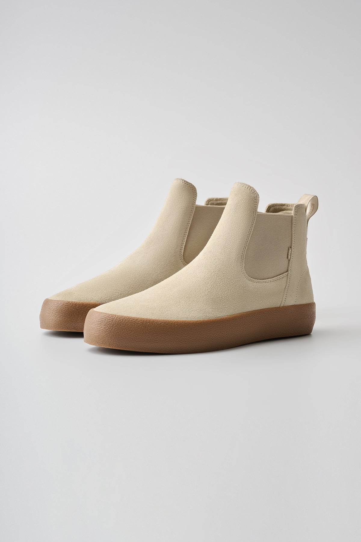 The Dover II - Safari/Crepe features beige slip-on ankle boots with elastic side panels and light brown rubber soles, displayed on a neutral background.