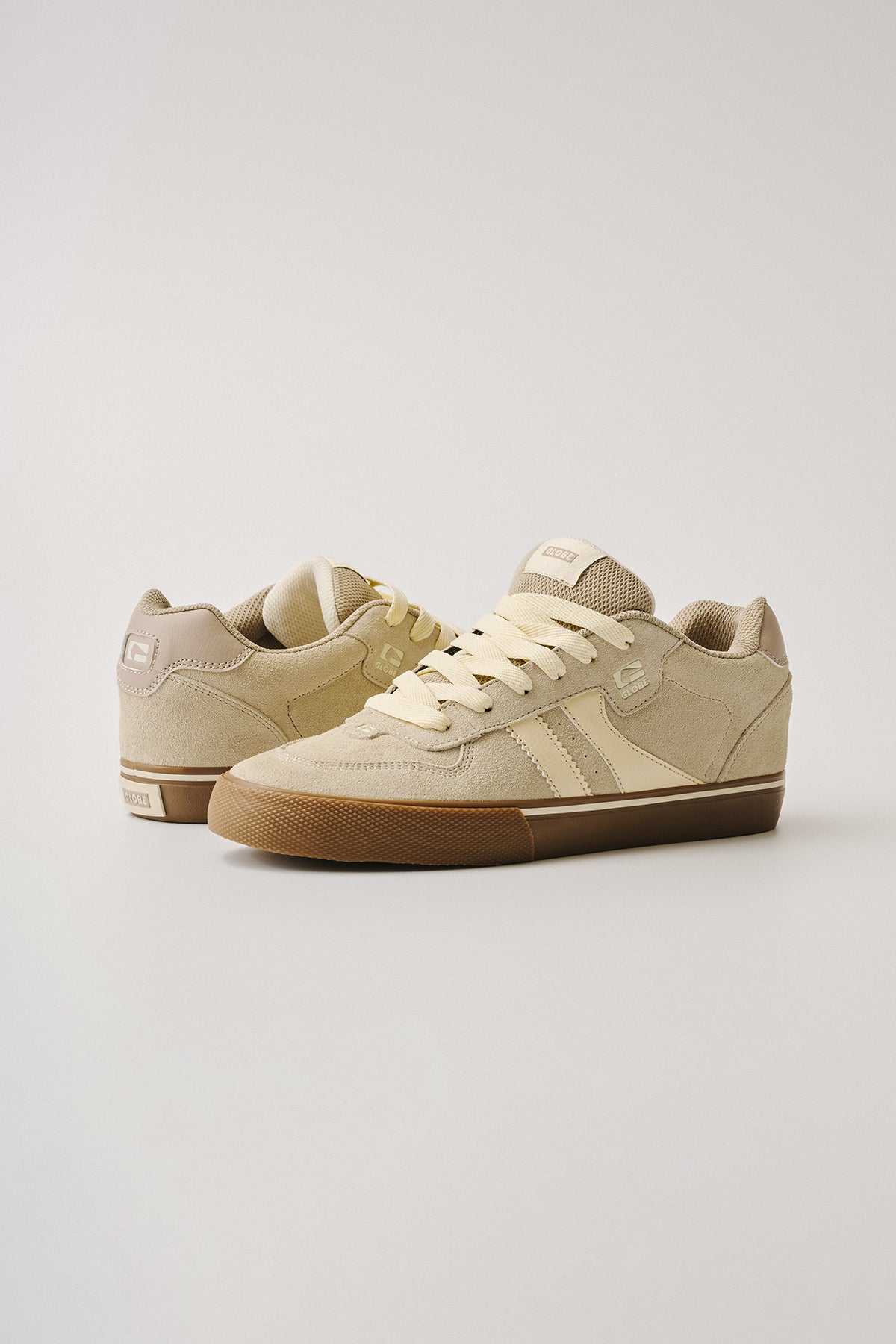 The Encore-2 in Grey/Tobacco Gum features suede uppers, cream laces, and light brown rubber soles. Displayed against a plain background, one shoe stands upright while the other angles slightly backward.