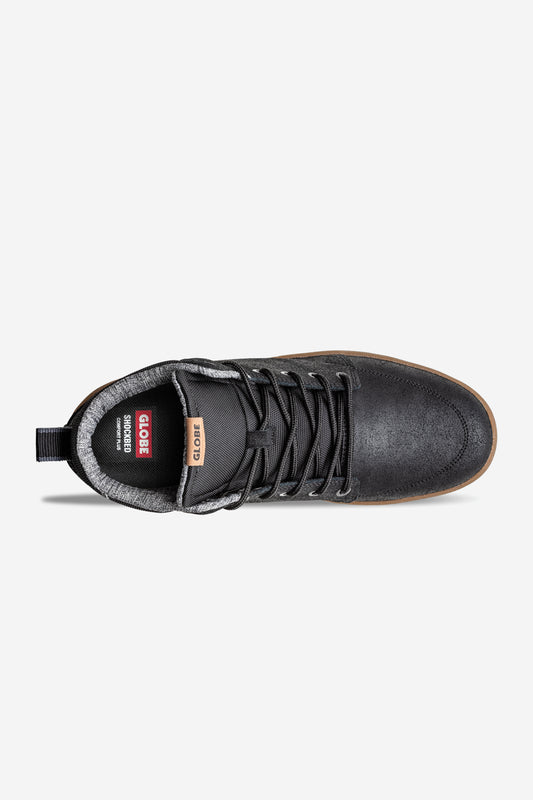 Top view of the black Globe GS Boot hi-top sneaker in oiled suede with black laces, gray padded collar, tan branded tongue label, textured finish, and brown outsole for a classic look.