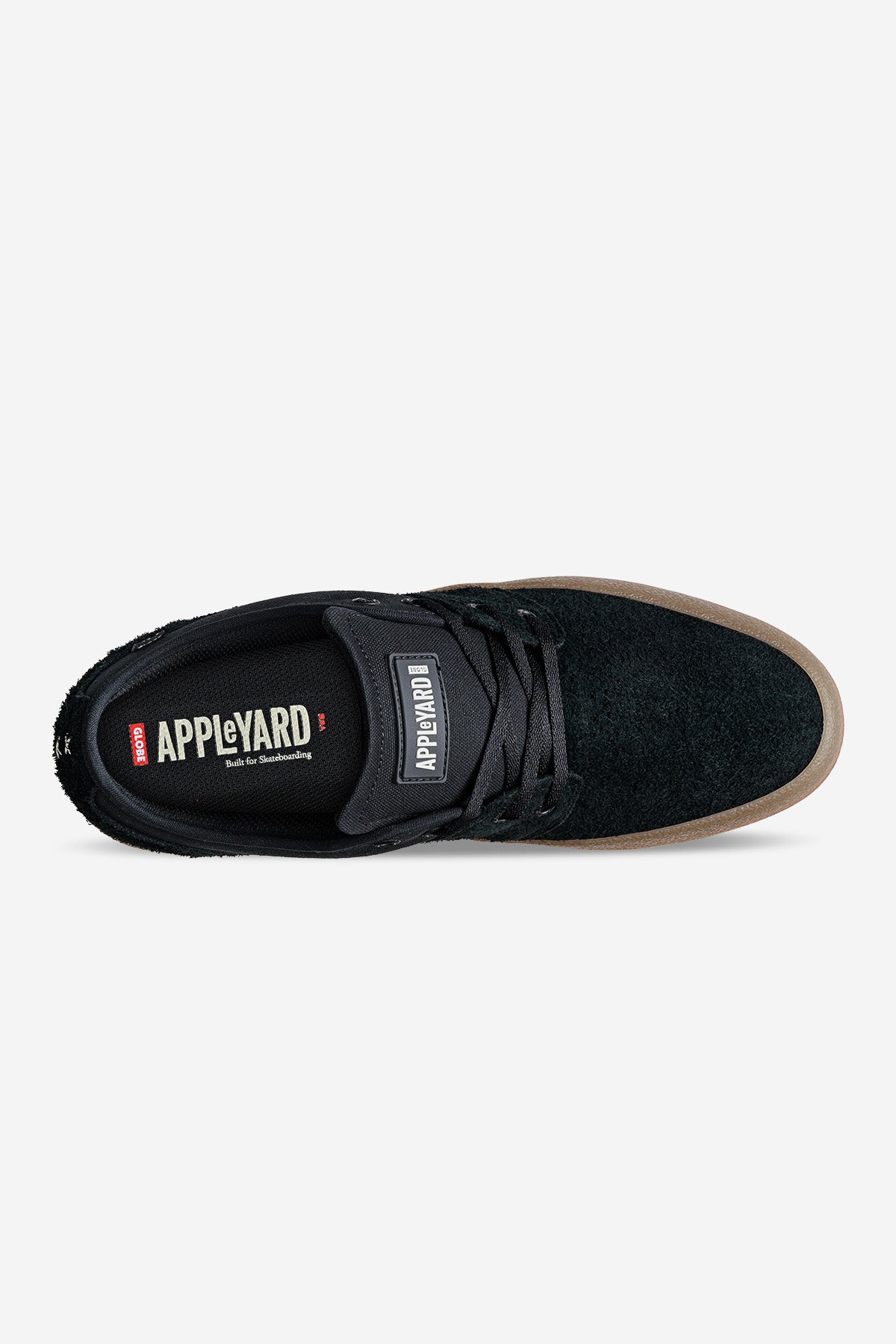 Top view of the Mahalo - Black/Gum/Crepe skate shoe featuring a black upper, brown gum sole, black laces, and APPLE YARD branding on the tongue and insole, positioned on a plain white background.
