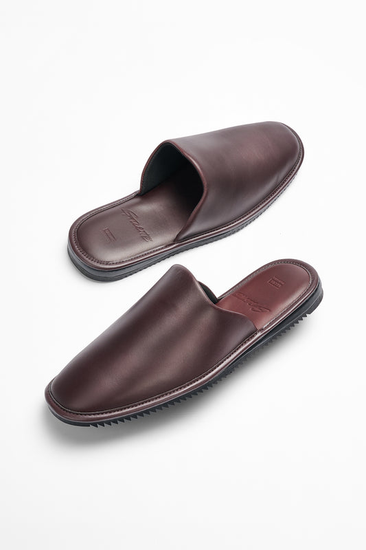 The Mule - Oxblood/Gillette is a pair of brown leather mule slippers with a durable Vibram sole, blending comfort and style.