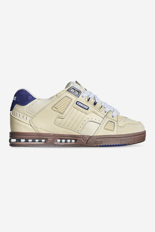 The Sabre - Antique White/Blue is a beige low-top sneaker with white laces, brown sole, blue and brown accents, perforated details, retro design, visible branding, and stitching.