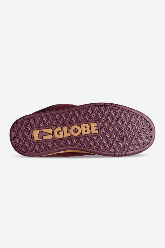 Bottom view of a maroon Globe Tilt sneaker showing a textured sole with an orange Globe logo