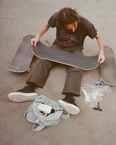 Lifestyle shot of skater setting up their board 
