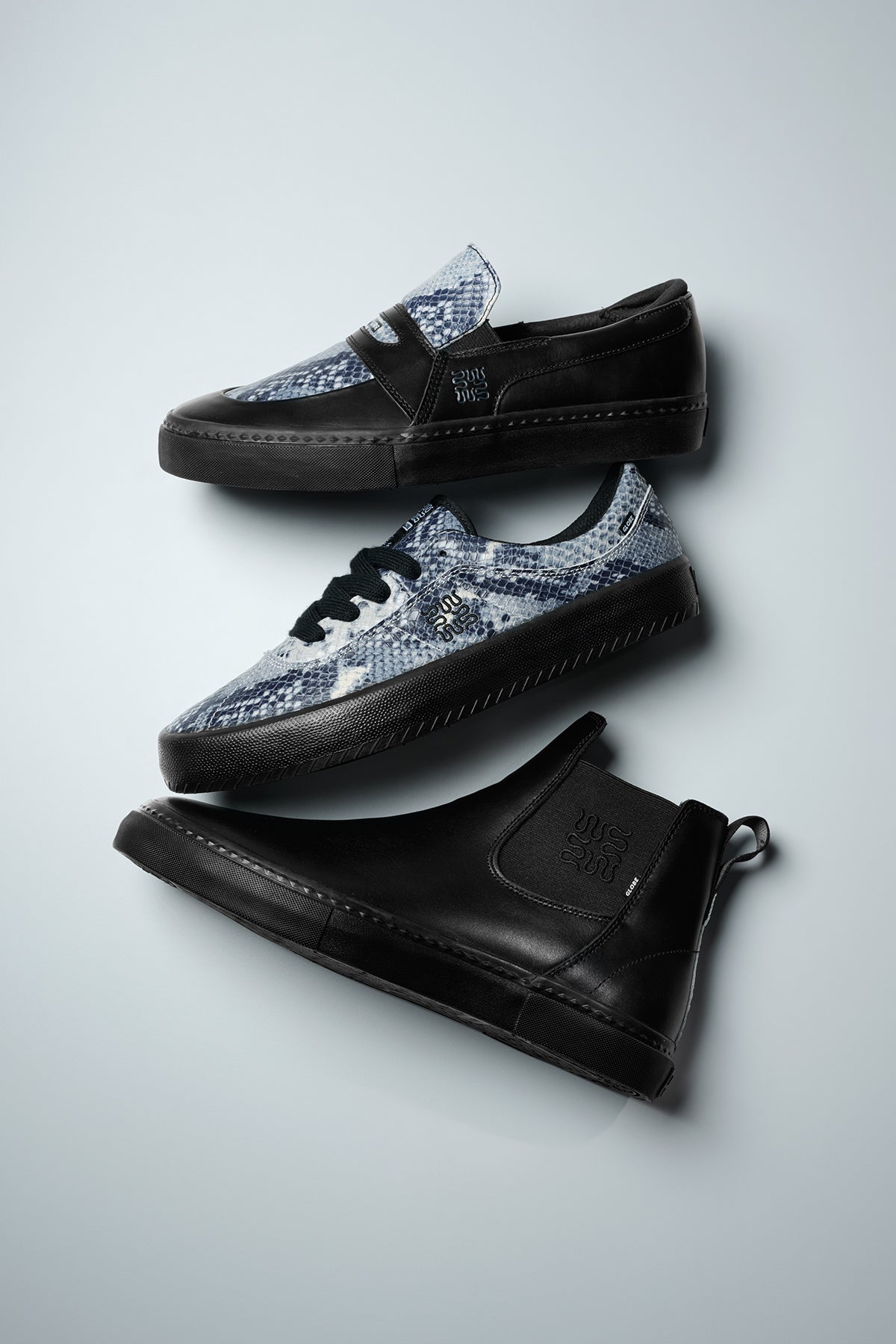 Three stylish Liaizon - Wasted Talent Black/Snake sneakers are displayed on a light gray surface: a blue and black snakeskin slip-on with Super-V outsole, a matching lace-up sneaker, and a solid black leather high-top.
