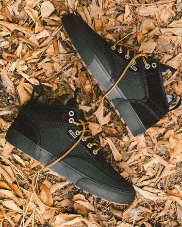 black motley mid trek shoes on leafy background