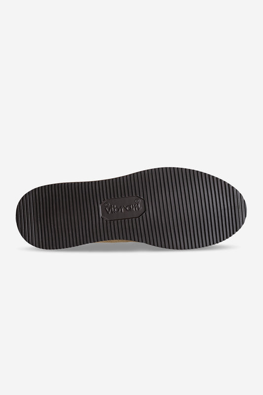 The Dover II Vibram - Taupe/MSFT features a black rubber Vibram outsole with fine horizontal grooves and an embossed logo at the center, shown from the bottom on a plain white background.