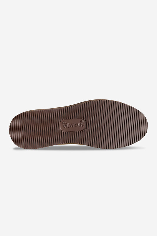 The image displays the brown, ribbed Vibram outsole of the Dover II Vibram - Brown Crazyhorse shoe, featuring "Vibram" embossed in the center and evenly spaced horizontal grooves across its length.