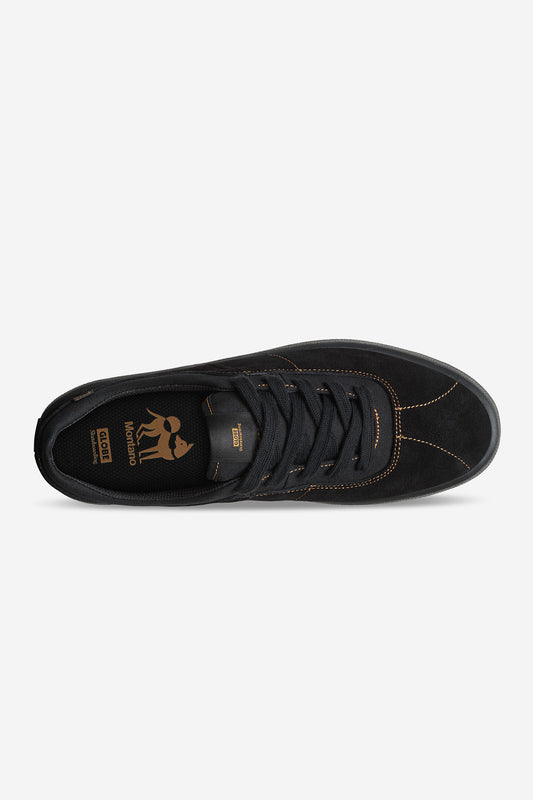 Top view of the Melbek - Black/Montano skate shoe with black suede upper, dark laces, brown stitching, gold insole branding, a rounded toe, and an abrasion-resistant rubber outsole for durability. Minimalist design.