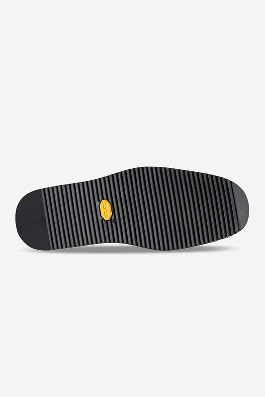 The Mule - Oxblood/Gillette shoe features a black Vibram sole with evenly spaced horizontal ridges and a small yellow hexagonal logo, photographed on a plain white background.