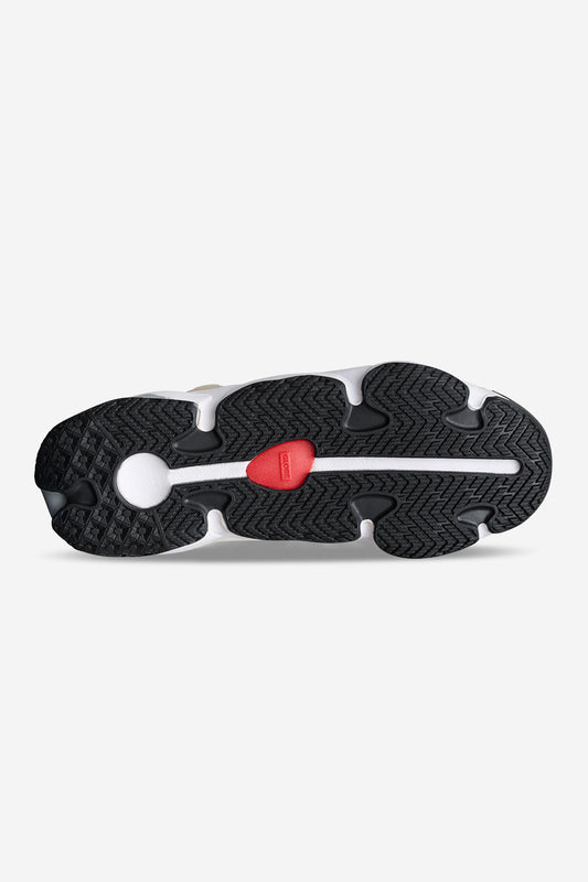 The image shows the sole of the Option Evo - Stone/Vanilla sneaker, featuring a black tread, a white circular patch near the heel, and a small red section by the arch. The heritage silhouette is highlighted with zigzag and curved tread patterns.