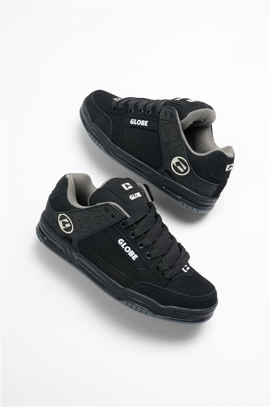 A pair of Tilt - Black/Black TPR Globe skate shoes with gray accents and white logos, shown angled on a white background. These leather skate shoes feature thick Strobo cup soles and padded collars.