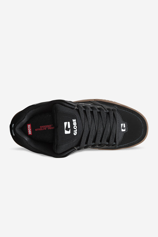 Top view of the Globe Tilt - Onyx/Gum skate shoe with black laces, gum S-Trac outsole, and white branding on the tongue and side. The insole features red Shockbed Insole + Flex text, highlighting its heritage skate silhouette.