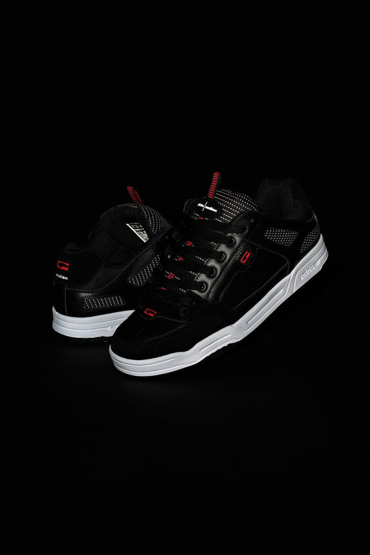 The Tilt Prime - Black / Mullen skate shoes, inspired by Rodney Mullen, are black leather with mesh details, red accents, white soles, visible branding, and laces on the upper—displayed on a black background.