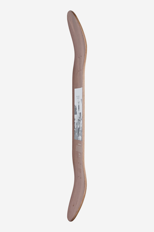 An Eames Silhouette Deck 8.25" - Hang-It-All stands upright, showcasing a natural walnut veneer, upward-curved ends, and a central black-and-white graphic inspired by Charles and Ray Eames’ iconic style.