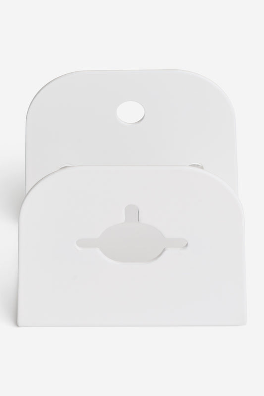The "Skateboard Deck Wall Hanger Accessories Hg 1sz" in white is a rectangular plastic mount with rounded edges, a circular top hole, and a center keyhole cutout shown standing against a plain white background.