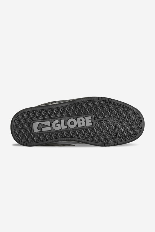 The image features the black rubber outsole of the Tilt - Dark Shadow/Phantom skate shoe, with GLOBE and its logo embossed at the center. Its tread combines triangles and zigzags for ideal grip on classic leather shoes with a Strobo cup sole.