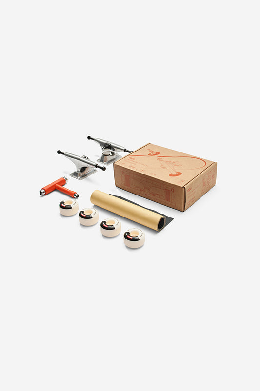The Everything But The Deck Kit Accessories Hg 5.0" - Raw Finish includes Slant trucks, four white wheels, a red T-tool, grip tape, bearings, and comes in a cardboard box—complete skateboard parts on a white background.